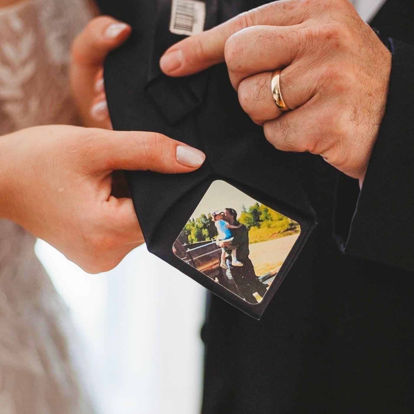 Hands revealing a personalized photo patch on the back of a tie